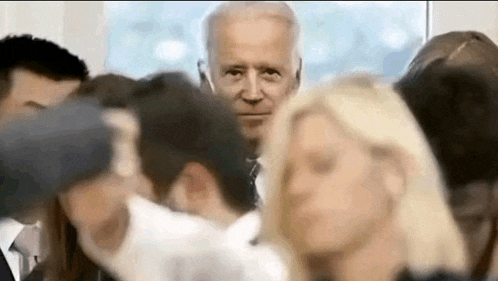 a man in a suit is standing in a crowd of people .