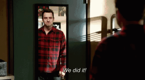 a man in a plaid shirt stands in front of a mirror and says we did it