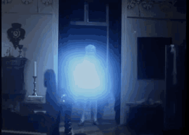 a person is standing in a dark room with a blue light coming out of them