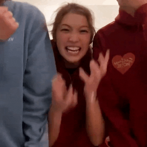 a group of people are standing next to each other and laughing .