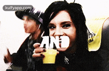 a woman holding a drink with the word and written on it
