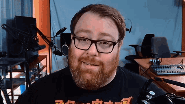 a man with glasses and a beard is wearing a black shirt that says ' tokyo ' on it