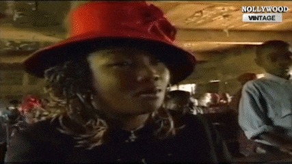 a woman wearing a red hat is sitting in a crowd .