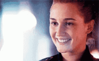 a close up of a woman 's face smiling in a blurry photo .