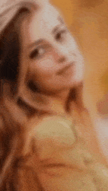 a blurry picture of a woman with long hair wearing a hat .