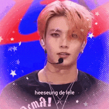 a young man wearing a microphone and a necklace with the words heeseung de lele on it .