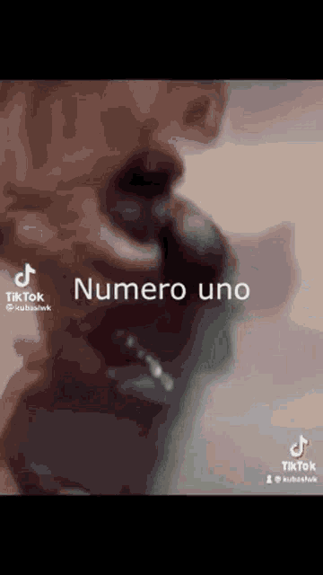 a man with a beard is singing into a microphone with the words numero uno written on it .