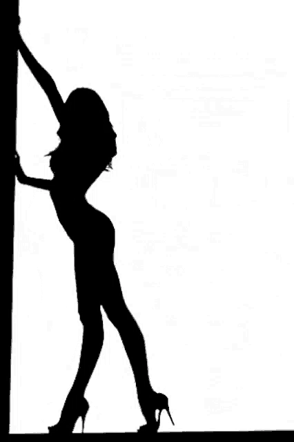 a silhouette of a woman standing next to a pole .
