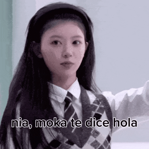 a girl in a school uniform is wearing a headband and a tie and says `` nia , moka te dice hola '' .