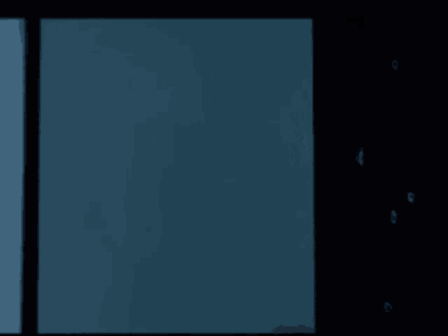 a woman with blue hair is peeking out of a window at night .