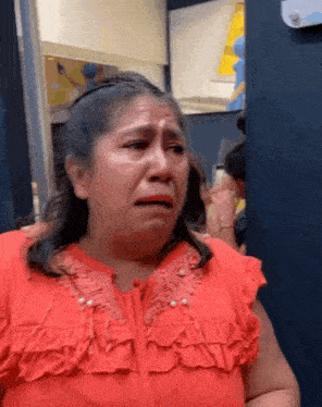 a woman in a red shirt is crying and making a funny face