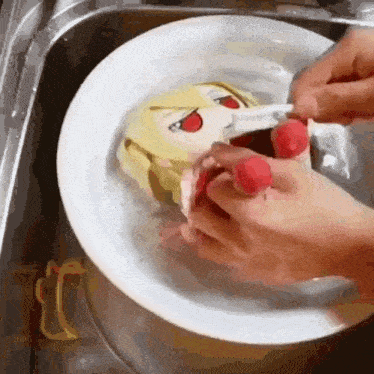 a person is washing a stuffed animal in a sink with a toothbrush .