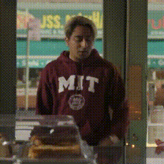 a man wearing a mit sweatshirt is standing in front of a store