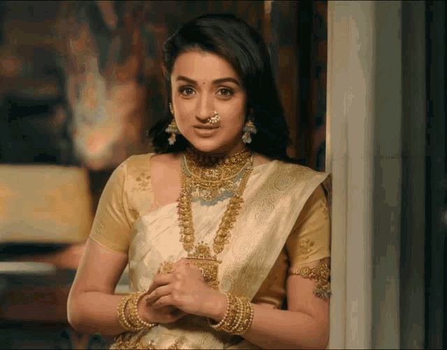 a woman with a nose ring is wearing a white saree