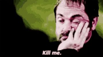 a man with a beard is holding his hand to his face and saying `` kill me . ''