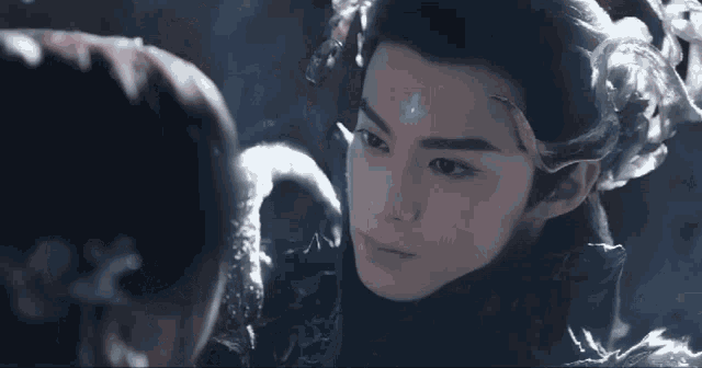 a man with a flower on his forehead is looking at another man
