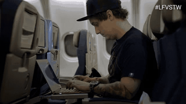 a man is typing on a laptop on an airplane with the hashtag #lfvstw on the bottom