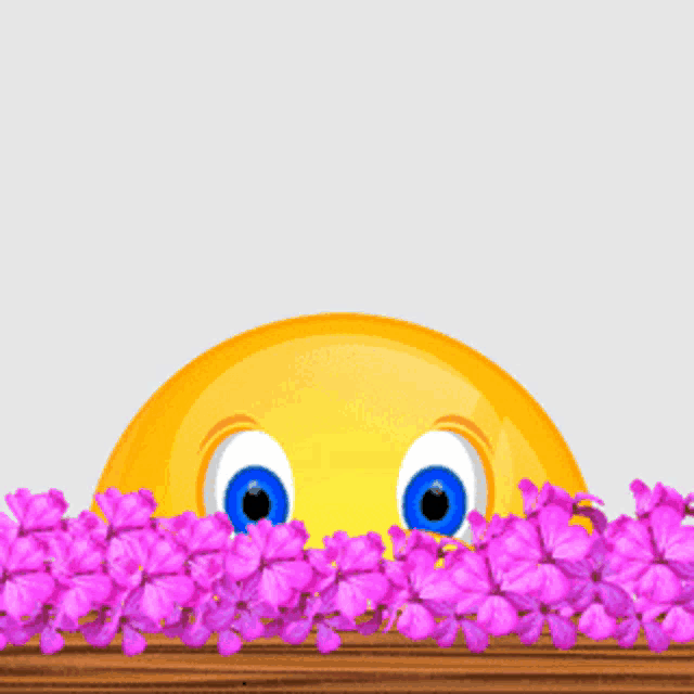a yellow smiley face is smiling in front of a pile of pink flowers