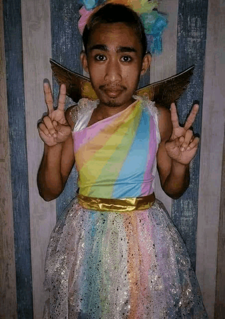a man dressed as a unicorn is giving a peace sign .