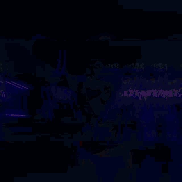 a man wearing a shirt that says ' supreme ' on it stands in a dark room