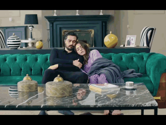 a man and woman are sitting on a green couch