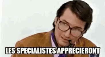 a man wearing glasses and a suit is talking on a telephone .