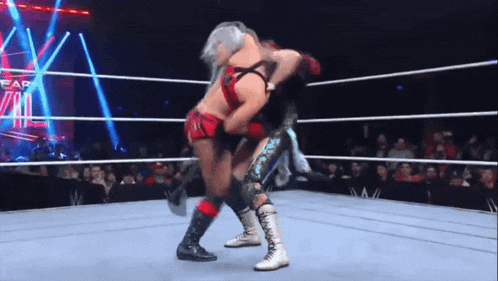 two women are wrestling in a ring with the word fear on the wall
