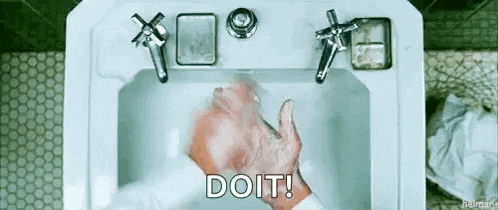 a man is washing his hands in a bathroom sink and says `` do it '' .