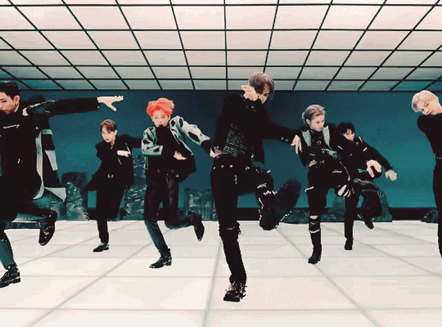 a group of young men are dancing in a room