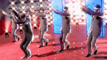 a group of men in suits are dancing on a stage in front of a wall that says ' a ' on it