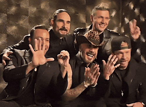 a group of men are posing for a picture and one has a cowboy hat on