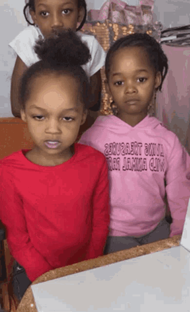 a little girl wearing a pink hoodie that says ' squirrel girl ' on it