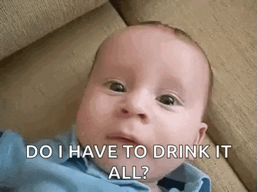 a baby is laying on a couch and making a funny face .
