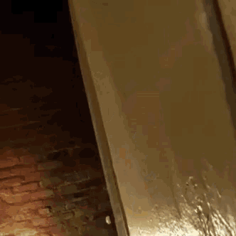 a dark room with a brick wall and a door that is open .