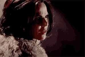 a close up of a woman 's face wearing a fur coat .