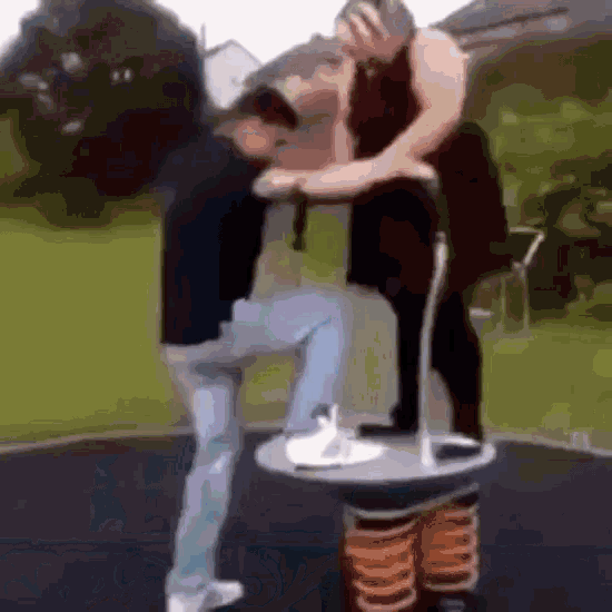 a man is standing next to a woman on a seesaw in a park .