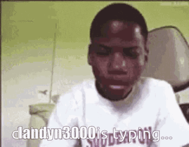 a man in a white shirt is sitting in front of a computer screen and typing .