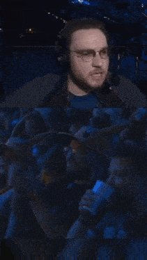a man wearing glasses and headphones is sitting in a crowd of people