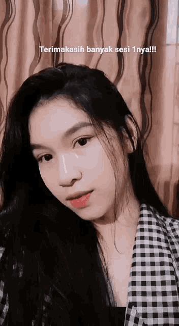 a girl with long black hair is wearing a black and white plaid shirt