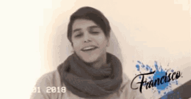 a young man wearing a scarf and a hat with the name francisco on the bottom