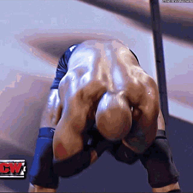 a wrestler is kneeling down in front of a cw logo