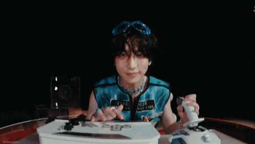 a man in a blue jumpsuit is dancing in front of a keyboard that says play