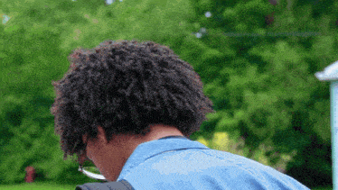 a man wearing glasses and a blue shirt is looking down