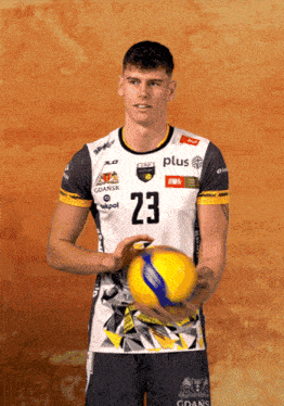 a man wearing a jersey with the number 23 holds a ball