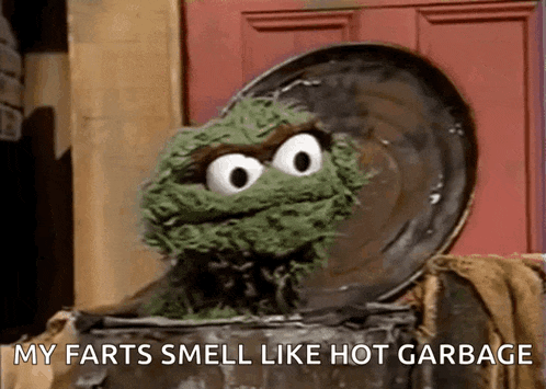 oscar the grouch from sesame street is sitting in a trash can