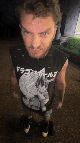 a man wearing a dragon ball z shirt is standing on a skateboard
