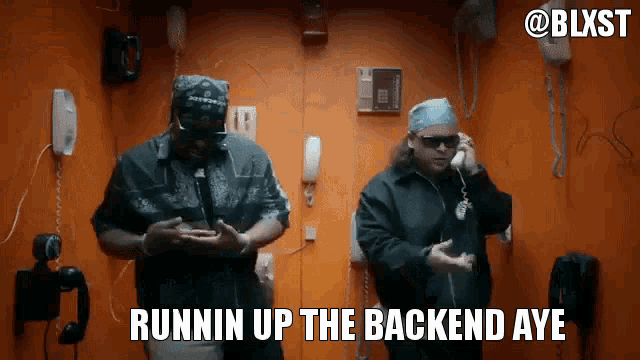 two men are standing next to each other in an orange room with the words runnin up the backend aye on the bottom