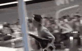 a blurry picture of a person sitting in a chair in front of a crowd of people .