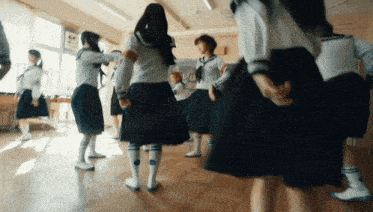 a group of girls are dancing in a circle in a classroom