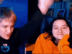 a man and a woman are sitting next to each other in front of a blue background .